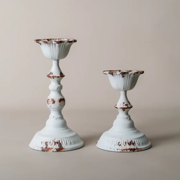 Ensemble de deux bougeoirs blanc en métal vieilli, parfaits pour une décoration romantique ou vintage avec des bougies effilées.