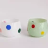 Coffret de deux verre à eau coloré posés sur un plateau traditionnel, apportant une touche artisanale et joyeuse.