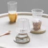 Verres à vins design en verre soufflé, utilisés pour un apéritif élégant sur une table claire.