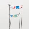 Lot de piques en métal représentant des vêtements miniatures suspendus, parfait pour une décoration de pot de fleur ludique et champêtre.