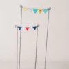 Ensemble décoratif pour jardinière avec vêtements peints suspendus sur des tiges en fer, idée originale de décoration de pot de fleur extérieure.