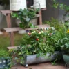 Décoration de pot de fleur avec guirlande de fanions au style rétro placée au centre d’une jardinière en métal.
