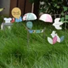 Piques décoratives en métal avec tee-shirt et chaussettes créant une décoration de pot de fleur animée.