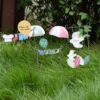 Ensemble de décorations de pot de fleur : ballons, parapluies et oiseaux formant une scène joyeuse sur l’herbe.