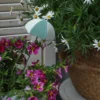 Petit parapluie vert d’eau dans un pot fleuri, idéal pour compléter une décoration pot de fleur romantique.