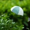 Accessoire de jardin original en forme de parasol vert et blanc pour une décoration pot de fleur estivale.