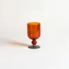 Vue rapprochée du pied décoratif des verres à vin, soulignant le travail artisanal et les reflets lumineux.