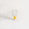 Gros plan sur les verres à vin avec pied orné d’une perle jaune, design moderne et élégant pour moments festifs.
