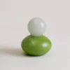 Diffuseur de parfum vert en verre soufflé avec boule blanche, parfait pour un intérieur naturel.