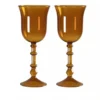 Verres à vin originaux posés sur une table blanche avec éléments de décoration florale.