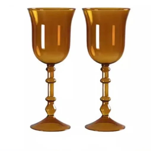 Verres à vin originaux posés sur une table blanche avec éléments de décoration florale.
