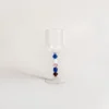 Verres à eau design exposés à plat, dévoilant la variation artistique des perles de leurs tiges.