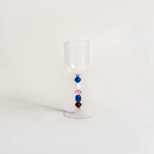 Verres à eau design exposés à plat, dévoilant la variation artistique des perles de leurs tiges.