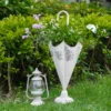 Pots de fleur design installés sur pelouse, avec effet patiné et fleurs fraîches dans un jardin rustique.