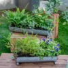 Zoom sur la poignée en fer forgé d’un pot de fleur long décoratif installé en extérieur.