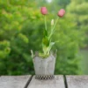 Pot de fleur petit en métal vieilli avec tulipes roses, idéal pour une décoration de table champêtre.