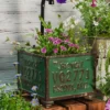 Zoom sur un pot de fleur pour balcon avec inscription rétro « PHOENIX, ARIZ. », entouré de fleurs colorées.