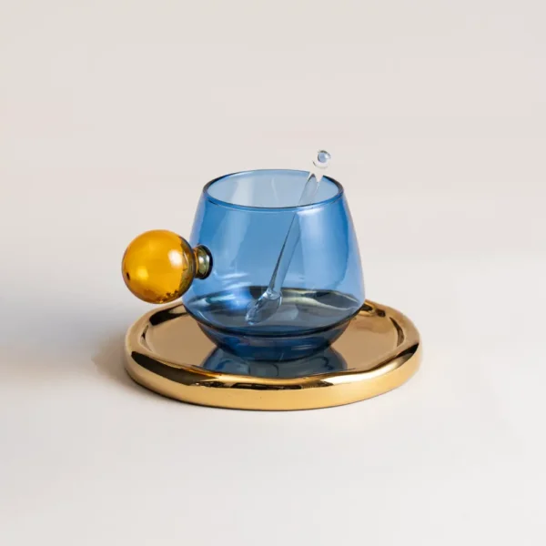 Verres à eau colorés avec anses sphériques sur soucoupe brillante, modèle bleu et doré