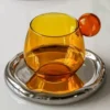 Verres à eau en verre soufflé teinté ambre avec soucoupe argentée assortie
