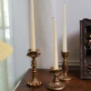 Bougeoir doré vintage mis en scène dans un intérieur lumineux avec rideaux clairs.
