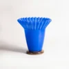 Vase bleu en verre soufflé au col ondulé, parfait pour une décoration moderne et audacieuse dans un intérieur lumineux.