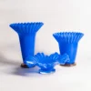 Trio de vase bleu design combinant formes hautes et coupelles pour une mise en scène florale créative et vibrante.