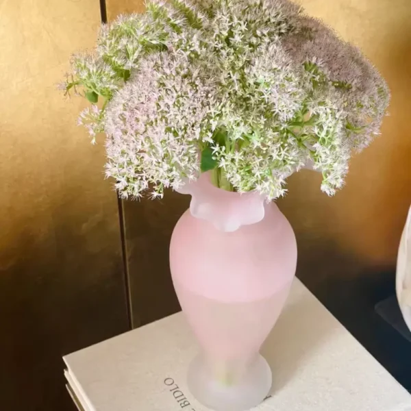 Élégant vase rose soufflé à la main, aux reflets doux, idéal pour une touche florale dans une décoration féminine.