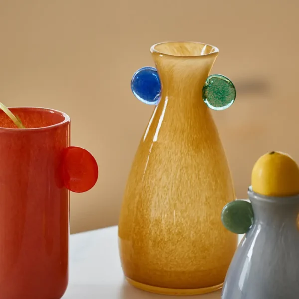 Collection de vase verre teinté en rouge, jaune et gris avec finitions brillantes, idéale pour une décoration intérieure moderne.
