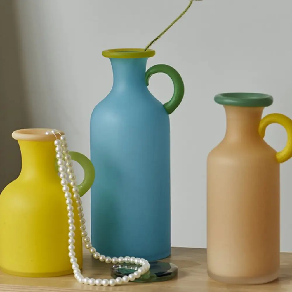 Collection de vases en verre aux finitions givrées, soulignant l’élégance des lignes et l’harmonie des tons translucides.