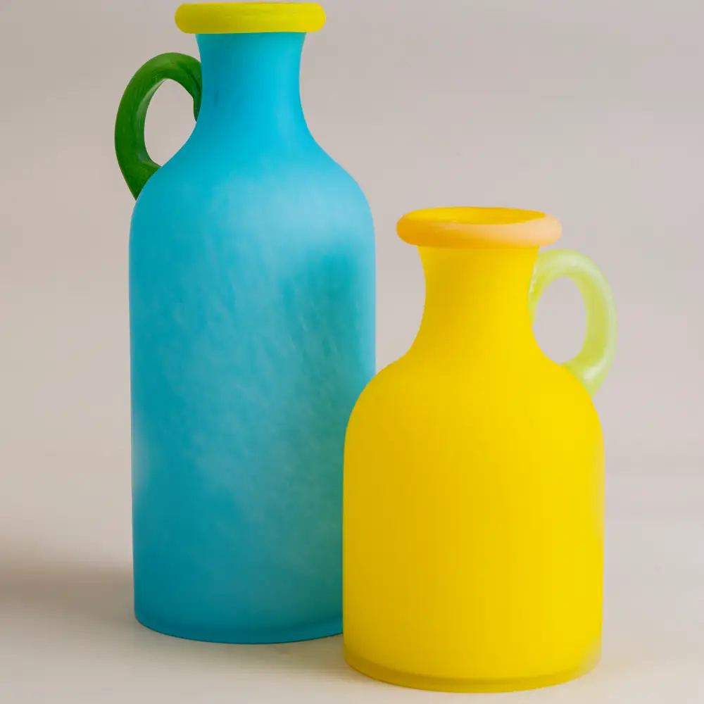 Composition de vases en verre coloré sur plateau minimaliste, idéal pour une décoration de table contemporaine et artistique.