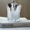 Vase en verre blanc sculptural placé sur un livre, diffusant une ambiance douce et moderne autour des vases et fleurs.