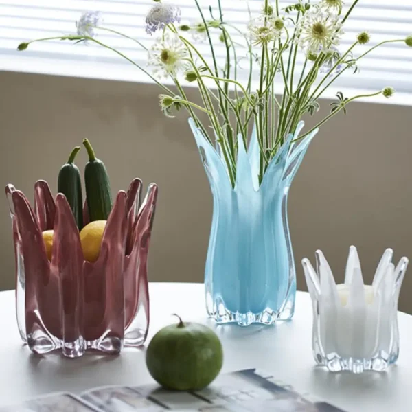 Composition florale aérienne dans un vase design en verre bleu, soulignant l’élégance des vases et fleurs soufflés.