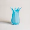 Vase bleu soufflé avec des fleurs sauvages, mettant en valeur un design unique de vases et fleurs.