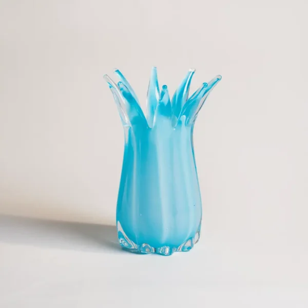 Vase bleu soufflé avec des fleurs sauvages, mettant en valeur un design unique de vases et fleurs.