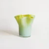 Petit vase en verre soufflé vert avec col ondulé, idéal pour une décoration de table moderne.