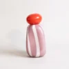 Vase rayé rose avec bouchon orange, idéal comme diffuseur d’huiles essentielles ou vase minimaliste.